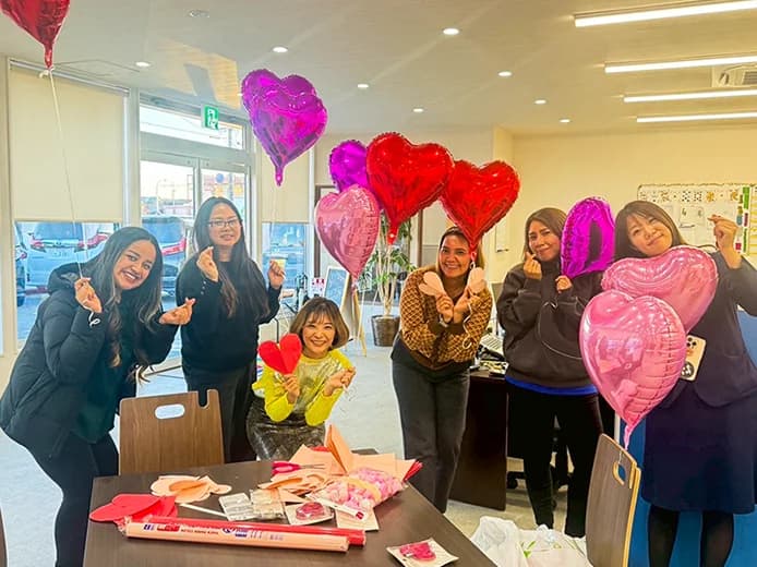 Staff smiling with a heart-shaped balloon